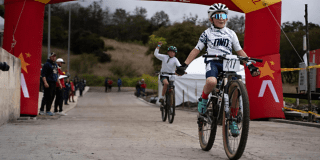 Imagen de un bicicrocista menor de edad pasando la línea de meta y celebrando
