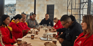Imagen de varios funcionarios en una mesa hablando