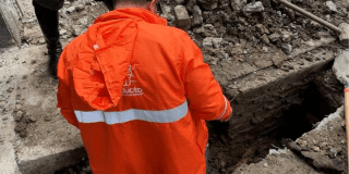 Imagen de un técnico de la empresa de Acueducto realizando mantenimiento en un tubo de alcantarillado.