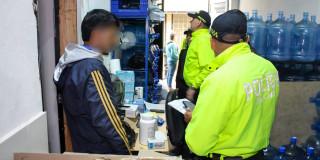 Policías de la SIJIN en allanamiento a embotelladora clandestina en Bosa.
