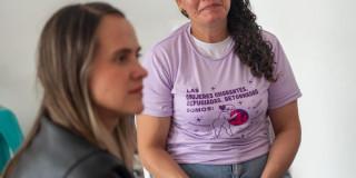 Secretaria Laura Tami con mujer migrante.