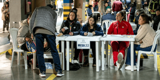 Imagen de gente votando en una mesa