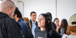 Imagen de una joven y un joven hablando y sonriendo