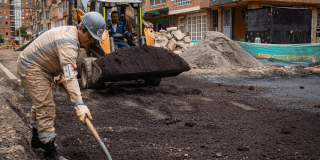 Imagen de un frente de obra vial con dos trabajadores parchando una calle