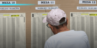 Imagen de un señor buscando su mesa de votación