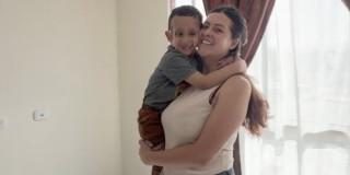 Foto que muestra a Sonya Esquivel alzando a su hijo. 