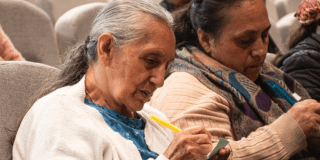 Imagen de dos señoras escribiendo en papeles