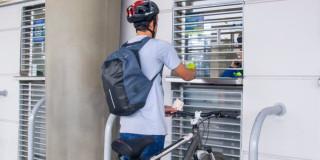 Foto de un ciclista en taquilla de una estación de TransMilenio en Bogotá.