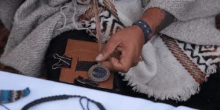 Imagen de unas manos que están trabajando en una artesanía en cuero.