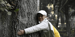 Foto de un hombre abrazando un arbol 