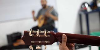 Foto que muestra una persona sosteniendo una guitarra