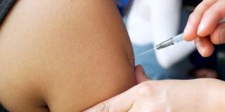 Foto que muestra una persona colocando una vacuna en un brazo