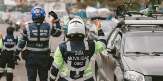 Foto de tres agentes de tránsito al lado de un carro