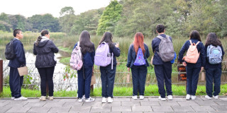 Foto que muestra estudiantes mirando un lago 