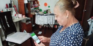 Imagen de señora viendo la pantalla de un celular