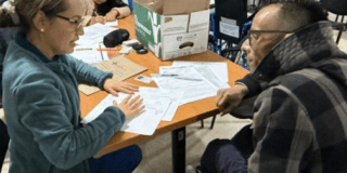 Imagen de una funcionaria hablando con una persona con discapacidad