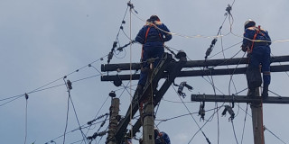 Foto que muestra personas con el uniforme de Enel Colombia realizando trabajos en un poste de luz