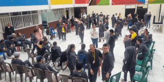 Imagen de varias personas en condición de discapacidad en un patio