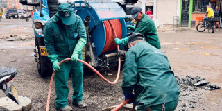 Foto que muestra tres personas con el uniforme del Acueducto de Bogotá