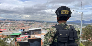 Militar mirando vista del sur de Bogotá en el horizonte.