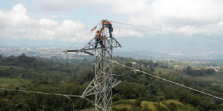Foto que muestra dos personas con el uniforme de Enel Colombia trabajando en una antena de energía