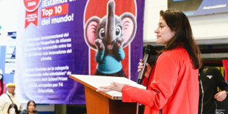 Foto que muestra una mujer hablando por un microfono 
