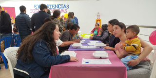 Imagen de varias personas hablando y compartiendo en una mesa