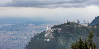 Foto pánoramica de Bogotá que muestra la iglesia de Monserrate, árboles y edificios 
