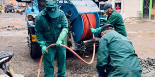 Foto que muestra tres personas con el uniforme del Acueducto de Bogotá