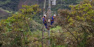 Foto que muestra dos personas con el uniforme de Enel Colombia realizando labores en una antena de energía 