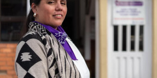 Mujer con una pañoleta morada.