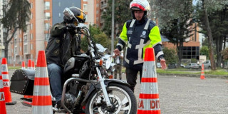 Foto de un motociclista y un funcionario de Movilidad 