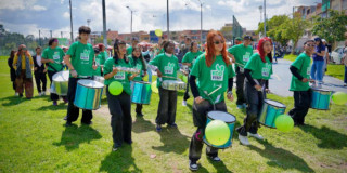 Foto que muestra personas tocando tambores en un parque 
