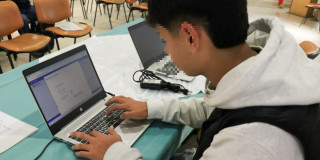 Foto que muestra a un hombre escribiendo en un computador 