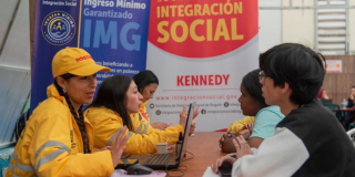 Imagen de funcionarios y personas hablando en la feria de servicios
