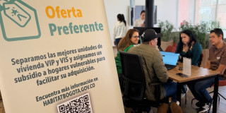 Foto que muestra un grupo de personas hablando sentadas en un escritorio