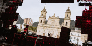 Imagen de una mujer dj tocando una consola al frente de la iglesia en la Plaza de Bolivar