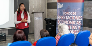 Foto de una mujer hablando con pensionados