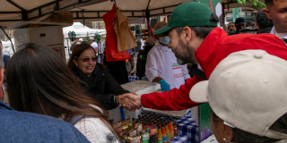 Imagen del alcalde Galán dándole la mano a una vendedora campesina