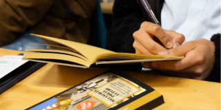 Imagen de una persona escribiendo a mano en un cuaderno.
