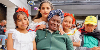 Imagen de una adulta mayor con varios niños y niñas