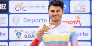 Edwin Matiz del Equipo Bogotá sostiene medalla dorada frente a panel institucional deportivo oficial nacional ciclismo