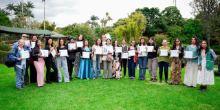 Grupo de participantes sostiene certificados tras formación en Jardín Botánico de Bogotá