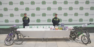 Uniformados de la Policía junto a mercancía incautada y bicicletas recuperadas.