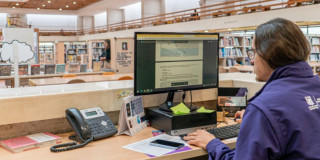 Imagen de funcionario de BibloRed trabajando en un computador