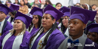 Foto que muestra hombres y mujeres con toga y birrete en una ceremonia de graduación 