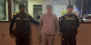 Hombre capturado en medio de dos policías en Bogotá.