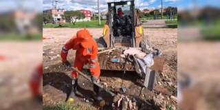 Foto que muestra trabajadores levantando residuos con una pala