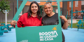 Foto que muestra dos mujeres sonriendo con un letrero que dice Bogotá mi ciudad mi casa