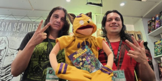 Dos hombres con un títere de un tigrillo.